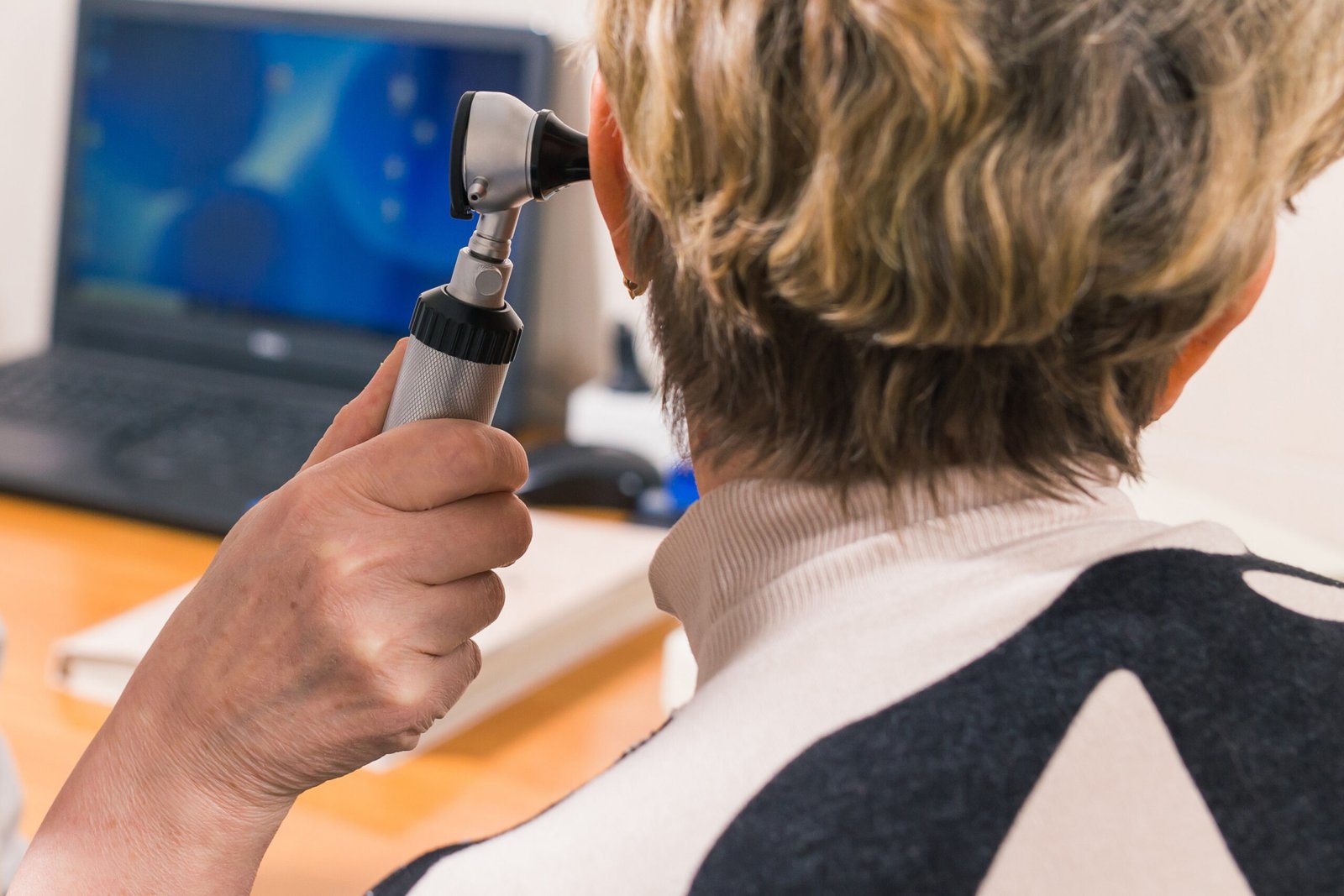 Doctor using otoscope instrument to check womans ear in hospital, Healthcare workers in the Coronavirus Covid19 pandemic